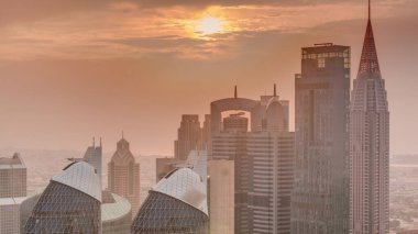 Dubai 'nin finans merkezi üzerinde gün batımı lüks gökdelenler zaman çizelgesi, Dubai, Birleşik Arap Emirlikleri. Turuncu gökyüzü ve çatıları olan hava manzarası