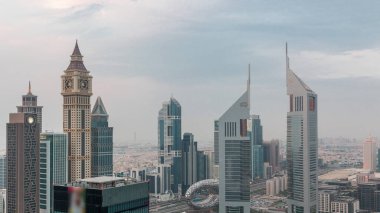 Sheikh Zayed Yolu 'ndaki gökdelenler ve Dubai, BAE' deki gece gündüz geçiş zamanları. Finansal merkez hava manzaralı kuleler. Gün batımından sonra bulutlu gökyüzü