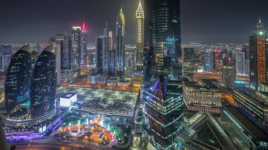 Sheikh Zayed karayolu zaman çizelgesinde Dubai 'deki finans bölgesi iş merkezindeki gelecekçi gökdelenlerin panoraması. Aydınlatılmış kuleler ve otopark ile yukarıdan hava görüntüsü
