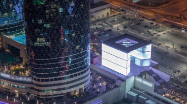 Geçit Bulvarı 'nın yeni gezinti güvertesi, Dubai Uluslararası Finans Merkezi' nde yer alıyor. DIFC 'deki tüm gökdelenleri birbirine bağlıyor. Parlak pencereli kuleler. Arabalı büyük bir otopark.