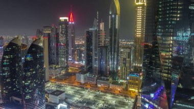Dubai 'nin finans merkezi, tüm gece boyunca aydınlık lüks gökdelenler, Dubai, Birleşik Arap Emirlikleri. Otoparkı ve çatıları sisle kaplı olan gökyüzü manzarası. Işıklar kapanıyor.
