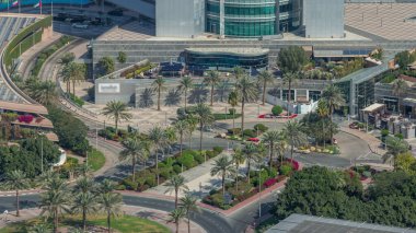 Dubai 'nin finans bölgesindeki kavşak kavşağı yolunun yukarıdan görünüşü. Sokakta trafik vardı, avuçlar gökdelenin girişine yakındı. Dubai, Birleşik Arap Emirlikleri.