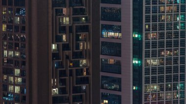 Gecenin ilerleyen saatlerinde gökdelenlerin dış tarafındaki pencereler zaman ayarında parıldıyor ve yanıp sönüyor. Havadan üst görünüm