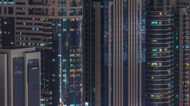 Gecenin ilerleyen saatlerinde gökdelenlerin dış tarafındaki pencereler zaman ayarında parıldıyor ve yanıp sönüyor. Havadan üst görünüm