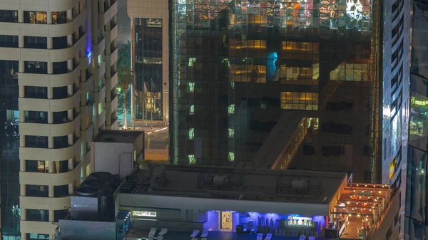 顶部游泳池从夜间时间上方俯瞰 高耸的摩天大楼照亮了金融区的空中俯瞰 人们放松 阿联酋 — 图库照片