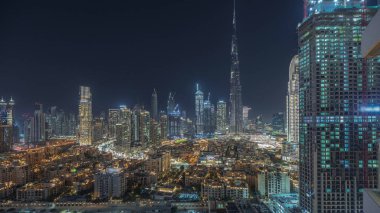 Panorama, Dubai Şehir Merkezi ve Business Bay gece zaman çizelgesini gösteriyor. Dubai 'deki en yüksek gökdelen ve diğer aydınlık kuleler, Birleşik Arap Emirlikleri manzaralı..