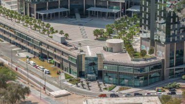 Dubai 'nin finans bölgesindeki ofis kulelerine yakın avuçları olan çatı bahçesi. Yol ve otoparklı hava manzarası