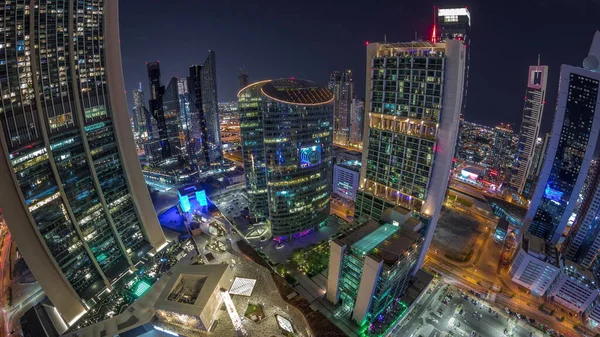 迪拜国际金融中心摩天大楼的全景在通宵的空中掠过 有城门大道的长廊和清真寺 从上方看明亮的塔楼 — 图库照片