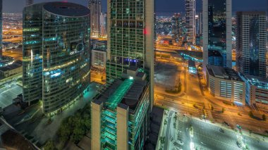 Dubai Uluslararası Finans Merkezi gökdelenleri gece gündüz geçiş zamanları. Güneş doğmadan önce yukarıdan parkedilmiş panoramik manzaralı kuleler