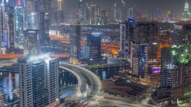 Dubai İş Koyu 'nun modern mimarisi ve finans bölgesinin Skyline' ı gece kuleleri aydınlatıyor. Kanal ve inşaat alanının üzerinde köprü olan hava manzarası