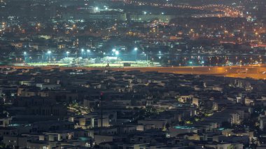 Dubai 'deki birçok apartman dairesinin hava görüntüsü. Lüks villalar ve gece ışıkları olan spor alanları.