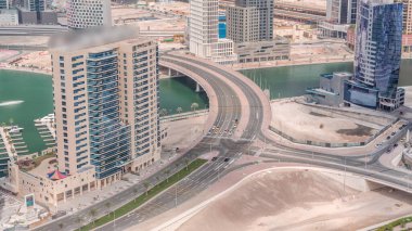 Yol kesişimleriyle Skyline ve Dubai iş sahası kulelerinin modern mimarisi. Kanal ve inşaat alanının üzerinde köprü olan hava manzarası
