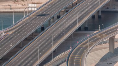Business Bay Timelapse 'da kanal üzerindeki kavşak köprüsündeki şehir trafiği. Yukarıdan yol kavşağının havadan görünüşü, otomobil trafiği ve birçok arabanın sıkışıklığı