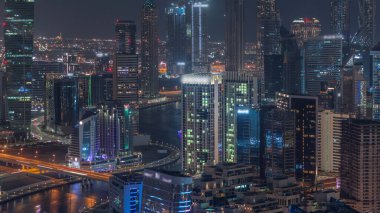 Dubai 'nin modern mimarisine sahip Skyline gece kuleleri aydınlatıyordu. Kanal ve inşaat sahasında köprüleri olan hava manzarası