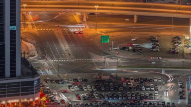 Bir otoparkın havadan görüntüsü. Gece vakti bir sürü araba geliyor. Dubai şehir merkezi yakınlarındaki iş sahasında trafik yoğun.