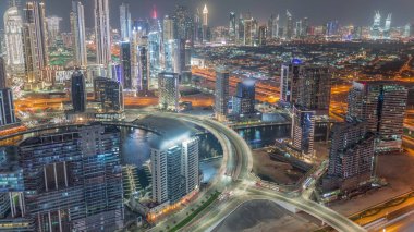Dubai 'nin modern mimarisine sahip Skyline gece kuleleri aydınlatıyordu. Kanal ve inşaat alanı üzerinde kesişen ve köprü olan hava manzarası