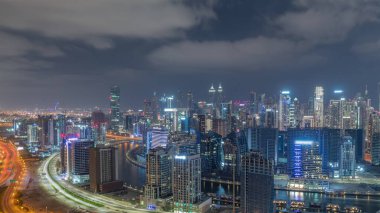 Dubai 'nin modern mimarisine sahip Skyline tüm gece panoramik zaman dilimi boyunca kuleleri aydınlattı ve ışıklar söndü. Kanal ve şantiyeli hava manzarası