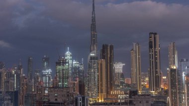 Dubai şehir merkezinin panoramik silueti gece gündüz iş sahasından geçiş zamanı. Gündoğumundan önce birçok modern gökdelenin havadan görünüşü. Birleşik Arap Emirlikleri.