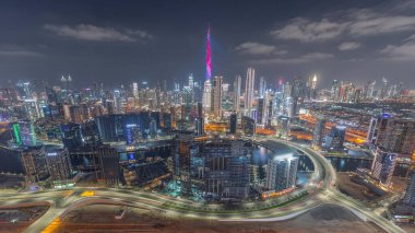 Dubai 'nin panoramik silueti, iş sahası ve şehir merkezi gece zaman çizelgesi. Birçok modern kulenin ve gökdelenlerin havadan görünüşü. Birleşik Arap Emirlikleri.
