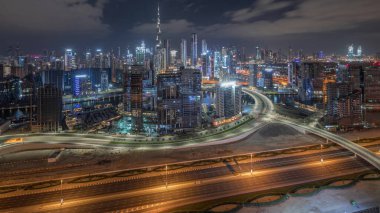 Panoramic skyline of Dubai with business bay with financial and downtown district during all night timelapse. Aerial view of many modern skyscrapers and busy traffic on al khail road. United Arab Emirates. clipart