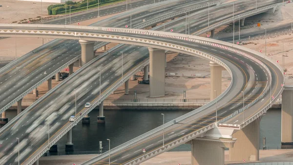 ビジネスベイのタイムラプスで運河に架かる橋のある横断道路上の都市交通を見る 上からの道路の交差点の空中トップビュー 自動車の交通や多くの車のジャム — ストック写真