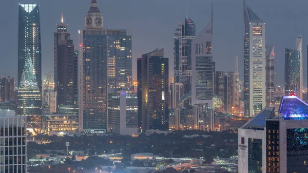 迪拜金融区的一排排摩天大楼从夜到一天的过渡时间过去了 日出前可从商业区俯瞰许多照明塔的全景 — 图库照片