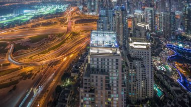 Dubai marinası ve JLT, Sheikh Zayed Yolu 'ndaki gökdelenleri büyük bir kavşak noktası olan gece zaman çizelgesiyle aydınlattı. Yukarıdan konut ve ofis binaları.