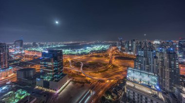JLT ve Dubai Marina arasındaki devasa kavşakta yükselen Ay panoramik gece zaman çizelgesi var. Yoğun trafiği olan kulelerin ve gökdelenlerin yakınındaki golf sahası