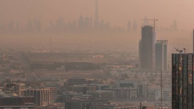 Dubai Şehir Merkezi 'nde gökdelenlerle dolu bir gökdelen silueti ve sabah sisli hava zaman çizelgesi var. Dubai yat limanının çatısından çok uzakta. Gün doğarken villalar. BAE