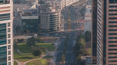 Gökdelenler arasındaki trafiğin yol çember kavşağının hava görüntüsü. Arabaları ve küçük parkları olan Dubai Marina ve BAE 'deki Medya Şehri' nin şehir manzarası