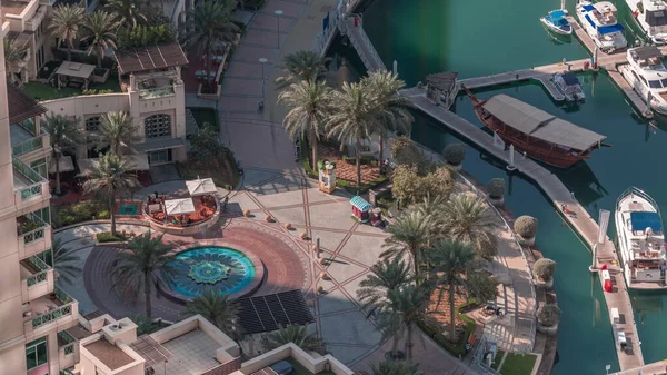 Dubai Marina rıhtımında havadan zaman ayarlı, Dubai, BAE. Birçok restoran, yüzen yatlar ve tekneler. Gölgeler hızlı hareket ediyor