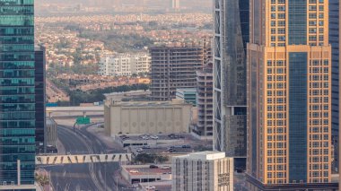 Dubai 'de hafif araçlar ve yol trafiği için park yeri. Lüks yerleşim yeri, hava manzaralı zaman aralığı. Çevrede gökdelenler ve arka planda villalar