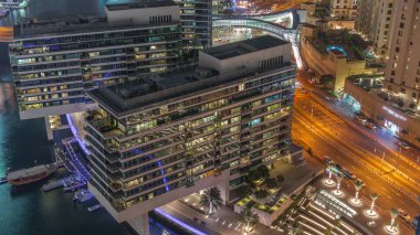 JBR ve Dubai Marina gökdelenleri, deniz kenarındaki modern gökdelenlerle birlikte gökdelenler, gece hava saatlerine göre apartmanlar. Yolda trafik vardı ve yürüyüş alanı yakındı.