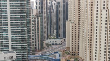 JBR ve Dubai Marina gökdelenleri, deniz kenarındaki modern gökdelenler, havadan sudan geceye geçiş zamanına bakıyor. Yol kavşağında trafik ve yaya geçidi