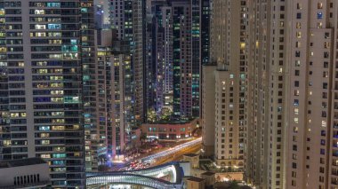 JBR ve Dubai Marina gökdelenleri, deniz kenarındaki modern gökdelenlerle birlikte gökdelenler, gece hava saatlerine göre apartmanlar. Yol kavşağında trafik ve yaya geçidi