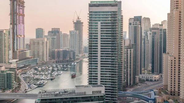 Havadan Dubai marina gökdelenlerine ve yüzen teknelerin zaman ayarlı olduğu kanal çevresindeki inşaat alanına. Yat kulübünün yakınındaki limanda beyaz tekneler var. Gün batımından önce akşam