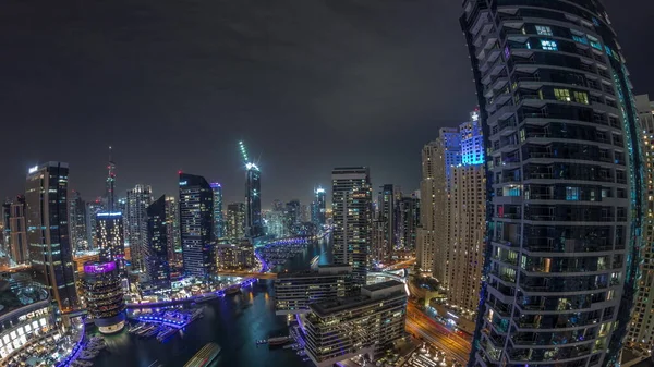 Dubai marinasına giden hava manzarası kanalın etrafındaki gökdelenleri aydınlattı. Tüm gece boyunca yüzen yatlar panorama boyunca ışıklar kapalıydı. Yat kulübünde beyaz tekneler var.