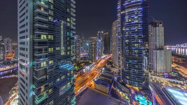 ドバイマリーナとJbrエリアのパノラマビューとライトアップされた高層ビルと道路の空中夜のタイムラプスのトラフィック — ストック写真