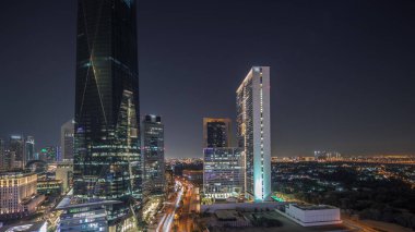 Dubai Uluslararası Finans Bölgesi Gece Zaman Çizelgesi. İş yeri kulelerinin panoramik hava görüntüsü. Elizabeth ilçesi yakınlarındaki otellerle aydınlatılmış gökdelenler.