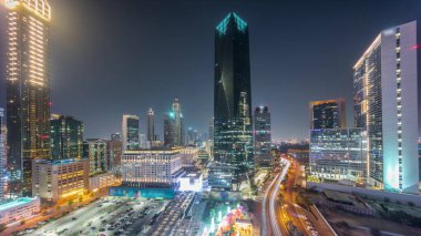 Tüm gece boyunca Dubai Uluslararası Finans Bölgesi. Panoramik ofis kulelerinin ışıkları kapalıyken görüntüsü. Şehir merkezine yakın park ve alışveriş merkezleriyle aydınlatılmış gökdelenler.