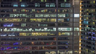 Geceleri ofis binalarının pencereleri, gökdelenlerin pencerelerinden gelen ışık. Parlak çalışma alanı olan şehrin akşam manzarası