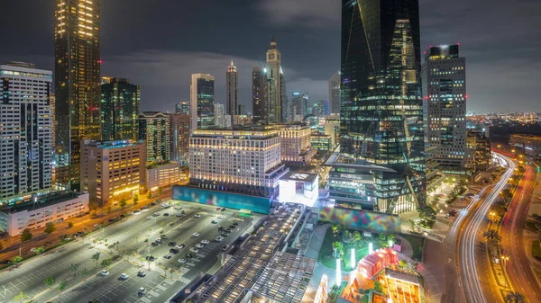 迪拜国际金融区彻夜未眠 市中心附近有灯光明亮的摩天大楼 有停车场和购物中心 商务办公大楼全景全景航拍 — 图库照片
