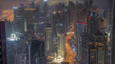 Dubai Marina 'nın Vew' ı, kıyı şeridi boyunca aydınlık gökdelenlerle çevrili kanalı gösteriyor. Gece gündüz geçiş zamanı. Güneş doğmadan önce yüzen yatlar ve tekneler. Dubai, BAE