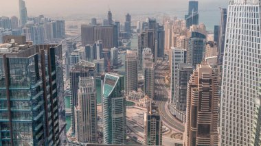 Dubai Marina 'nın Skyline panoramik görüntüsü tüm gün boyunca gölgelerin hızlı hareket ettiği, kıyı şeridi boyunca gökdelenlerle çevrili yapay bir kanal gösteriyor. Yüzen yatlar ve tekneler. Dubai, BAE