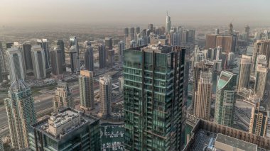 Dubai Marina ve JLT bölgesinde gökdelenler arasında trafik var. Modern kuleler ve inşaat alanı. Limanda yüzen yatlar