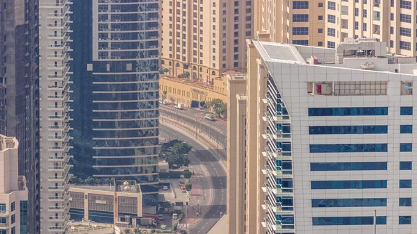 Yukarıdan JBR ve Dubai Marina gökdelenlerinin ve lüks binaların hava manzarası. Kavisli yolda trafik olan modern kuleler