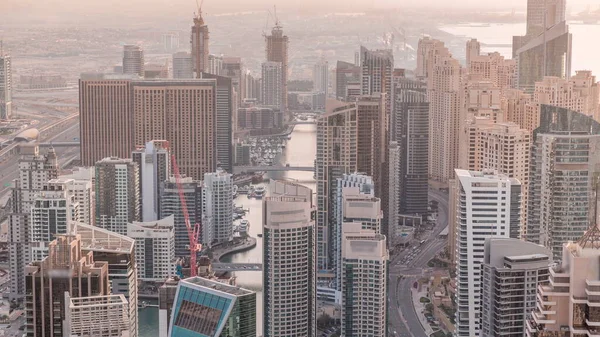 Gökdelenlerle çevrili Dubai Marina 'nın gökdelenlerle çevrili panoramik görüntüsü. Akşamları kıyı şeridi boyunca. Yüzen yatlar ve tekneler. Dubai, BAE