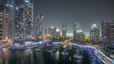 Şehirde lüks yat körfezi Dubai marinasında havadan gece saatleri.