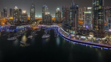 Şehirde lüks yat körfezi Dubai marinasında havadan gece saatleri.