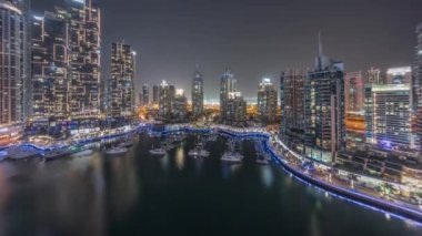 Şehirde lüks yat körfezi Dubai marinasında havadan gece saatleri.